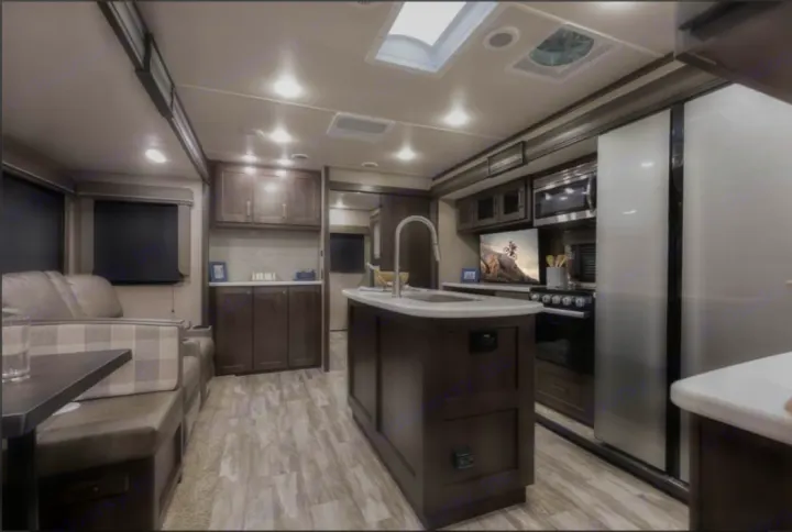 Modern RV rental interior with a fully equipped kitchen, island, stainless steel appliances, and comfortable living space.. Grand Design Reflection 2022