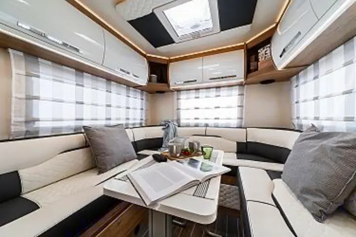 This spacious RV rental interior features a stylish U-shaped lounge and dining area, perfect for comfortable adventures.. Ford Rollerteam 747 2026
