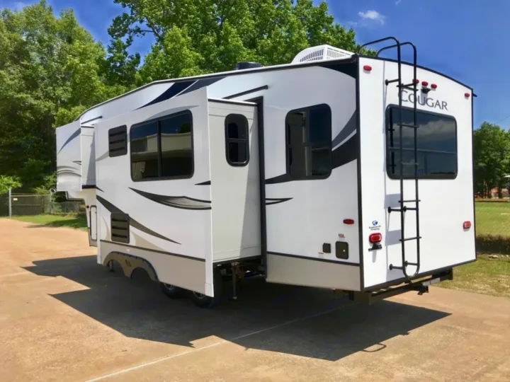 Experience freedom with this white Cougar fifth-wheel RV rental. Features multiple slide-outs and a rear ladder.. Keystone Cougar 2022