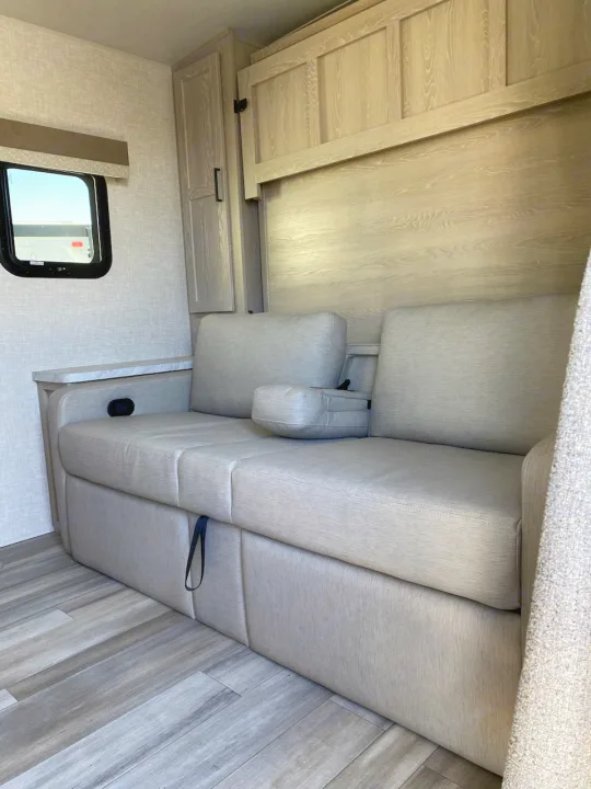 RV rental interior: Light wood cabinets & flooring complement comfy grey seating. Window view.. Flagstaff Microlite 2023