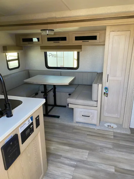 Spacious RV rental interior features a dinette, sleek cabinets, and light wood flooring. Ready for your adventure.. Flagstaff Microlite 2023