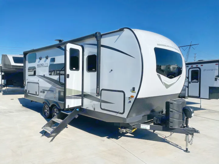 A sleek white and grey Micro Lite Flagstaff travel trailer, perfect for an RV rental, awaits your next road trip adventure.. Flagstaff Microlite 2023
