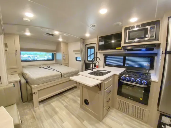 Explore this spacious RV rental interior featuring a full kitchen, comfortable bedroom, and dining area, ideal for your next adventure.. Flagstaff Microlite 2023