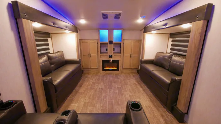 Modern RV rental interior: cozy living room with twin sofas, electric fireplace, and storage. Perfect for your next adventure.. Forest River Cherokee Arctic Wolf 2022