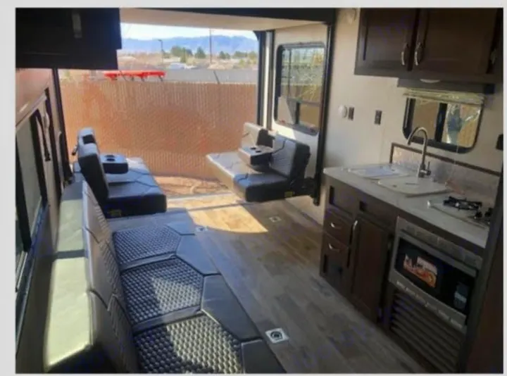 RV rental's roomy interior features a modern kitchen, adaptable seating, and a wide rear opening, ideal for a toy hauler.. Jayco Octane 2018