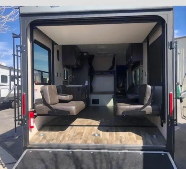 Explore this RV rental's versatile toy hauler interior. Features garage space, fold-down seating, kitchen, and bunk beds.. Jayco Octane 2018