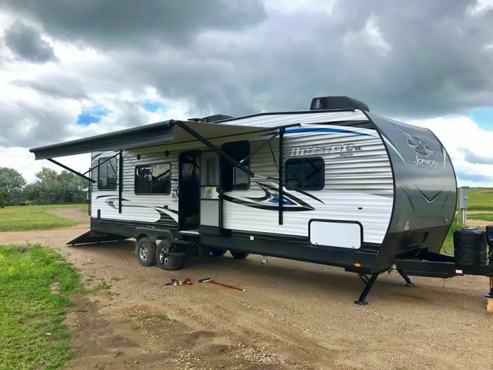 Spacious Jayco Octane SL travel trailer at a campsite, ready for your next rv rental adventure. Awning extended for shade.. Jayco Octane 2018