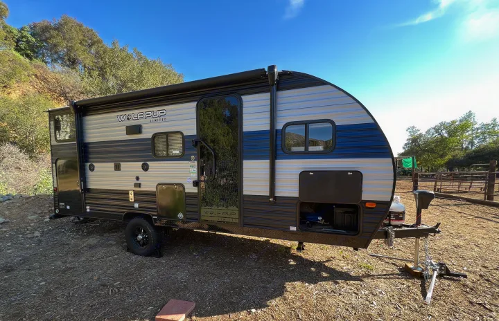 A Wolf Pup travel trailer RV rental, with awning out, parked outdoors for a sunny camping adventure.. Forest River Cherokee Wolf Pup 2022