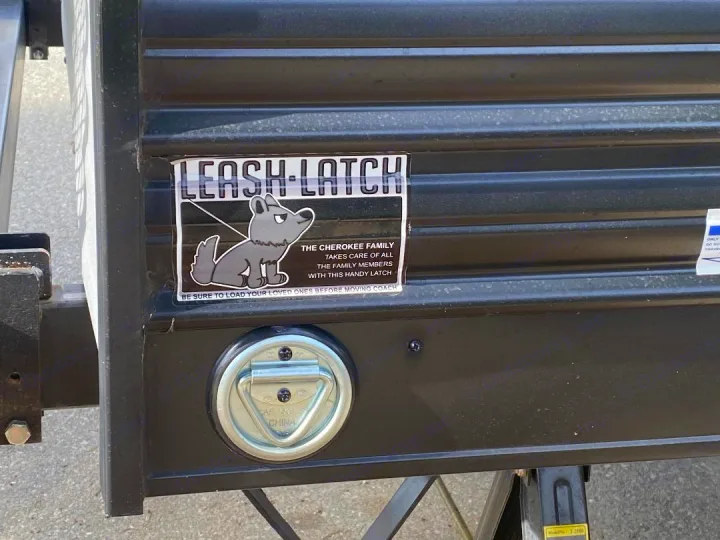 A "Leash-Latch" sticker and tie-down on an RV rental, highlighting a pet-friendly feature. Great for securing furry family members.. Forest River Cherokee Grey Wolf 2021