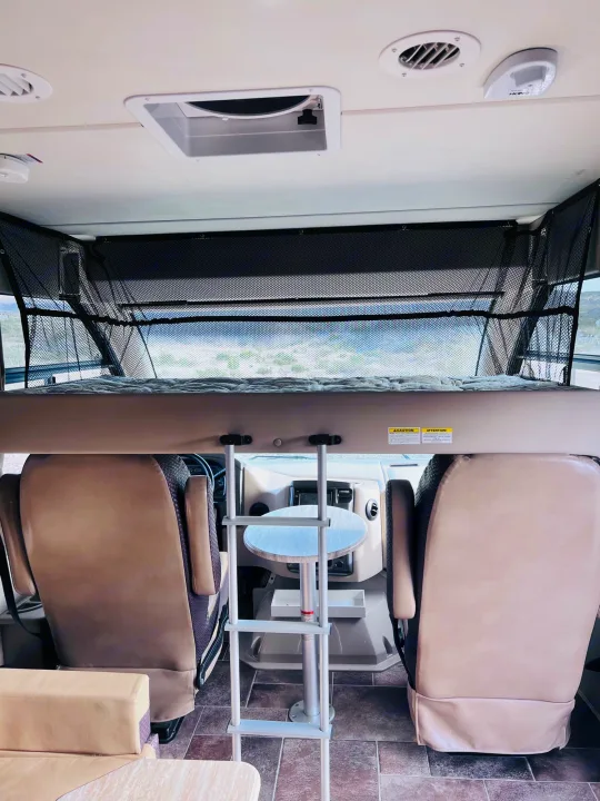 RV rental interior: Looking forward to the front cockpit, dinette with ladder, and cozy overhead bunk with safety net.. Thor Vegas 2017