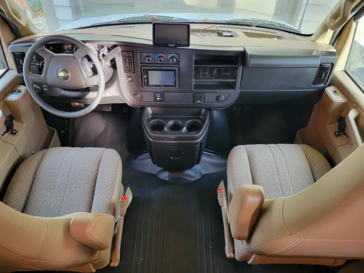 Bright RV rental interior: Dashboard with GPS, steering wheel, comfortable front seats, & practical center console.. Coachman Freelander 2019