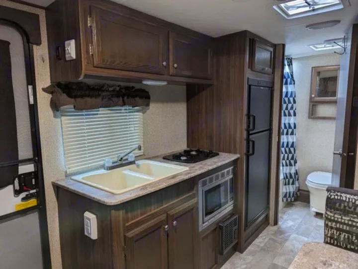 This RV rental offers a well-appointed kitchen with sink, stove, microwave, fridge, and a convenient compact bathroom.. Coachmen Apex Nano 2019