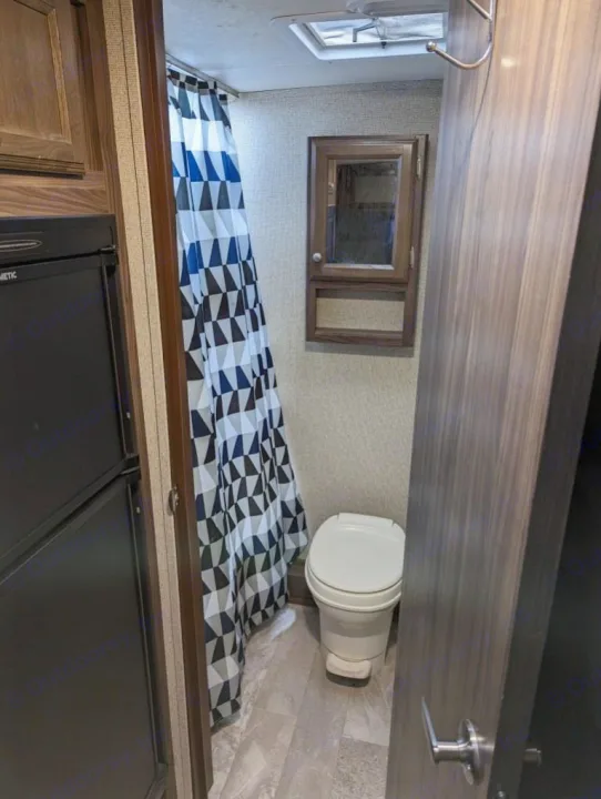 RV rental bathroom: Compact interior with toilet, shower curtain, and medicine cabinet.. Coachmen Apex Nano 2019