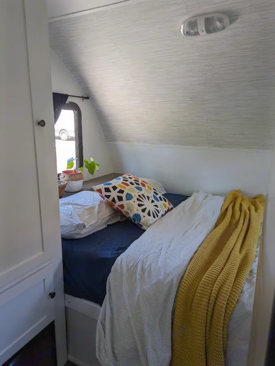 Interior of an RV rental: a cozy bedroom with colorful bedding, curved ceiling, and window view.. Gulf Stream Vista Cruiser M-19RSD 2013