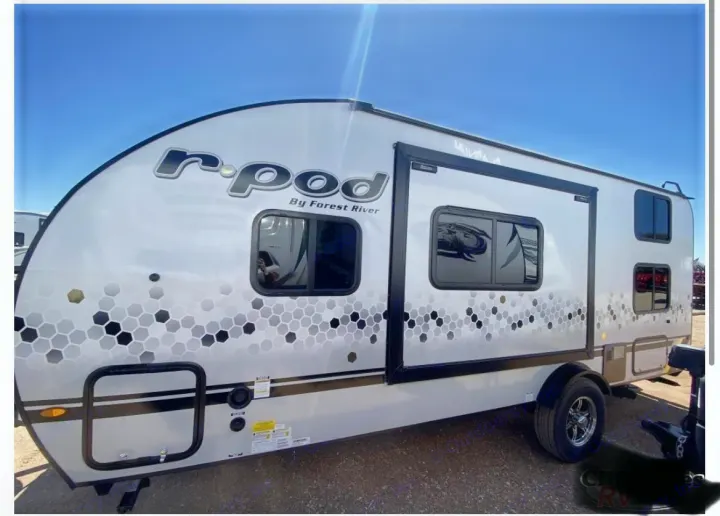 A sleek white r-pod travel trailer, branded 'Forest River,' with unique hexagon decals. Perfect for your next rv rental adventure!. Forest River R POD 193  H.R. EDITION 2022