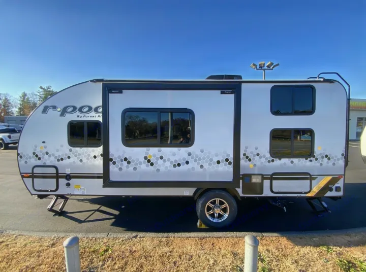 Side view of a white r-pod travel trailer with a gray and yellow hexagonal pattern, parked outdoors for rv rental.. Forest River R POD 193  H.R. EDITION 2022