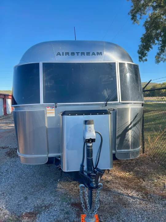 Front view of a sleek Airstream travel trailer, parked on gravel, perfect for your next RV rental trip.. Airstream Flying Cloud 2017
