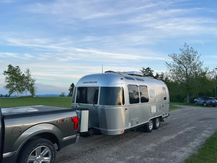 Silver Airstream travel trailer & F-150 4x4 truck on a scenic gravel lot. Your next rv rental adventure awaits!. Airstream Flying Cloud 2017