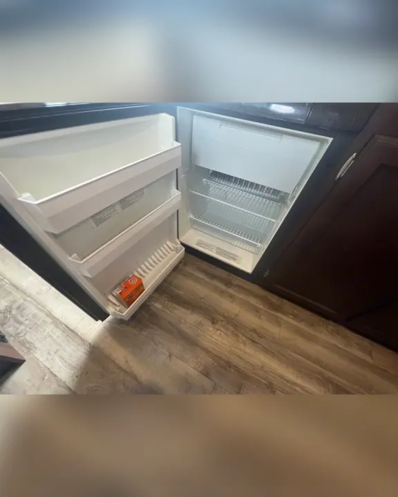 Inside an RV rental: clean, open refrigerator with wire shelves & door storage. Baking soda box visible.. Jayco Jay Flight SLX 2018