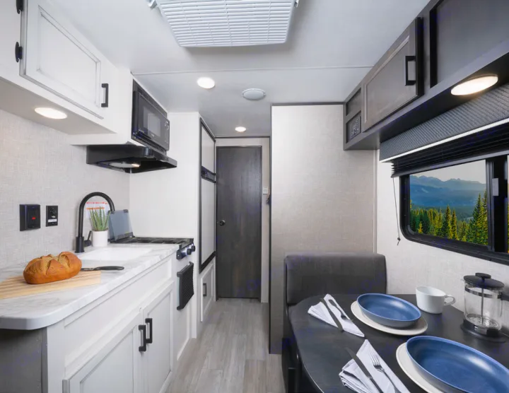 Modern RV rental interior with a fully equipped kitchen and a cozy dining area offering a scenic view.. Jayco Jay Flight SLX 2022