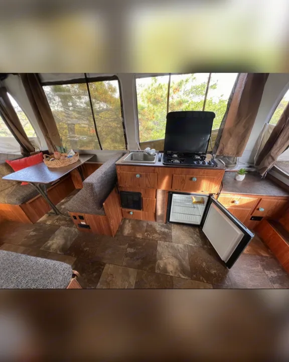RV rental interior showing a compact kitchen with sink, stove, fridge, and dinette seating. Perfect for camping!. Flagstaff/ForestRiver M.A.C.SeriesM-228 2016