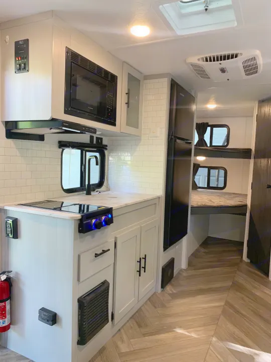 Modern RV rental interior showcasing a well-equipped kitchen, bunk beds, and ample amenities for your next adventure.. Forest River Salem FSX 2021