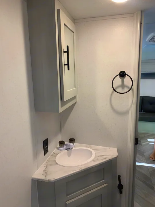 Modern RV rental bathroom vanity with sink, towel ring, and built-in storage.. Forest River Salem FSX 2021