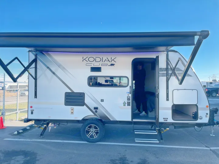 White Kodiak Cub travel trailer with an extended awning & LED lights, ideal for your next RV rental.. Dutchmen Kodiak Cub 175BH 2022