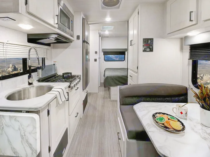 Explore this well-equipped rv rental featuring a kitchen, dining booth, and private bedroom area. Perfect for your next adventure.. Forest River Entrada 2022