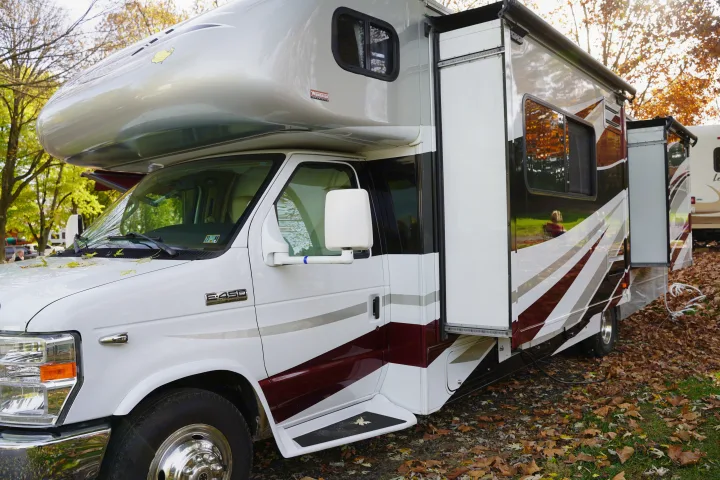 This Winnebago Class C RV rental, parked amidst fall leaves, shows its extended side for more space.. Itasca Impulse 2013