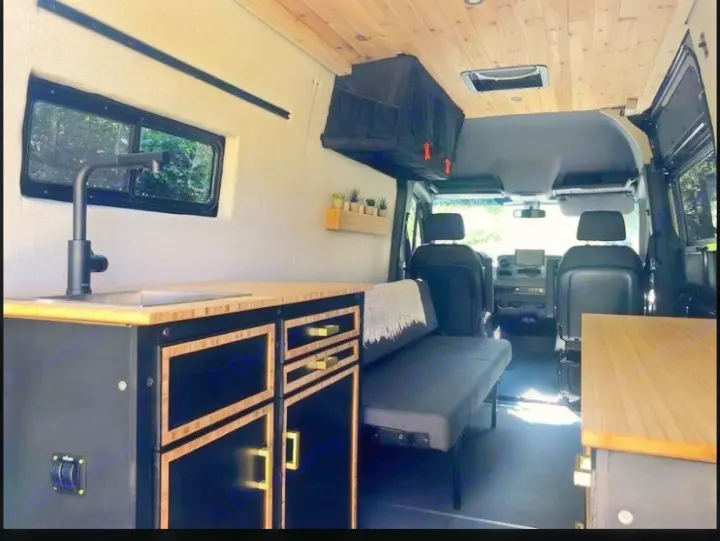 Sleek, custom camper van interior featuring a kitchen, seating, and cozy living space. Ideal for an rv rental.. Mercedes Sprinter 2021