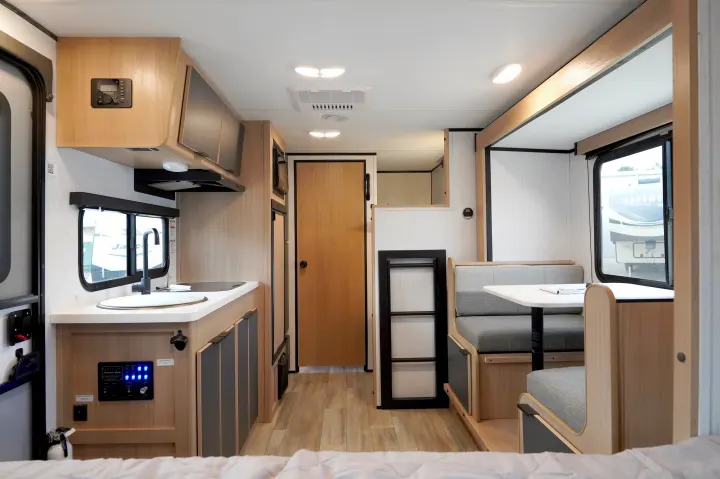 This rv rental features a compact kitchen with a sink, cabinetry, and a comfortable dinette seating area.. Cruiser Rv Corp Hitch 2022