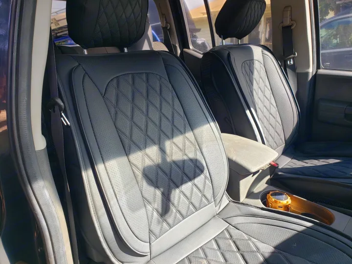 Plush black quilted seat covers adorn this rv rental interior, offering comfort. Sunlight illuminates the vehicle's upgraded seating.. Other Other 2015