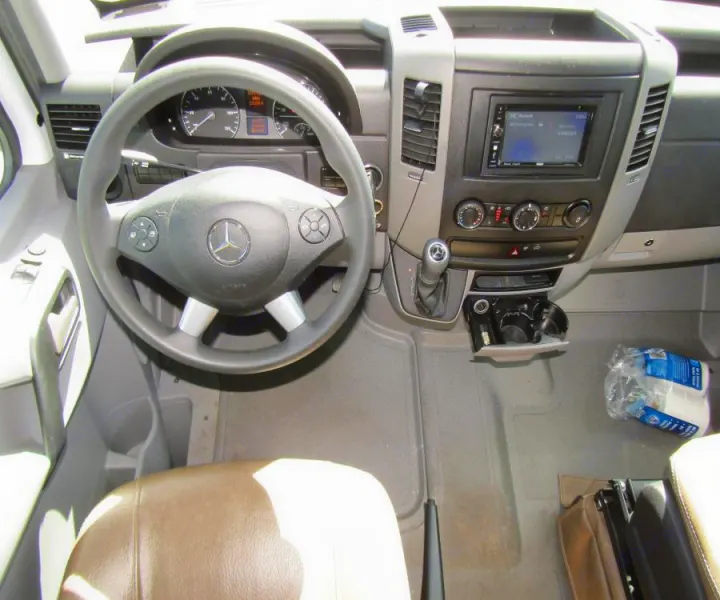 RV rental interior: Mercedes Sprinter driver's area showing steering wheel, dashboard, and controls.. Coachmen Prism 2022
