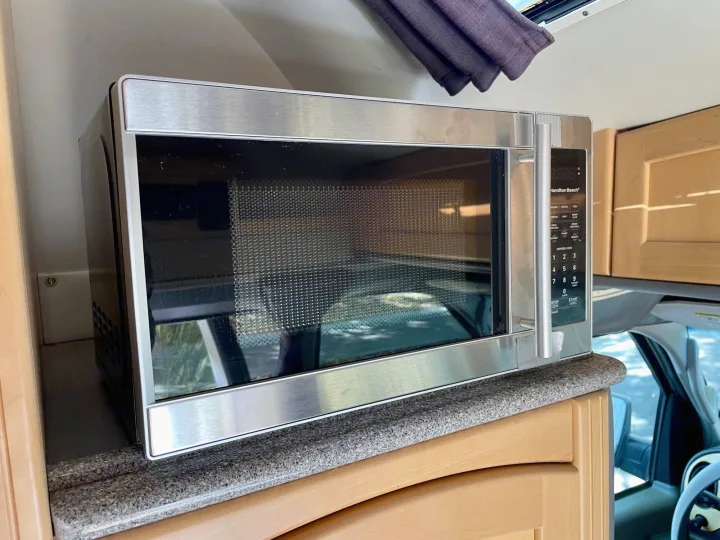A stainless steel Hamilton Beach microwave in an RV rental, a compact kitchen appliance for convenient travel meals.. Pleasure Way Excel 2007