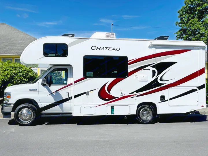 Bright white Chateau RV rental, a Class C motorhome with striking red and black graphics, parked and ready for travel.. Thor Chateau 2022