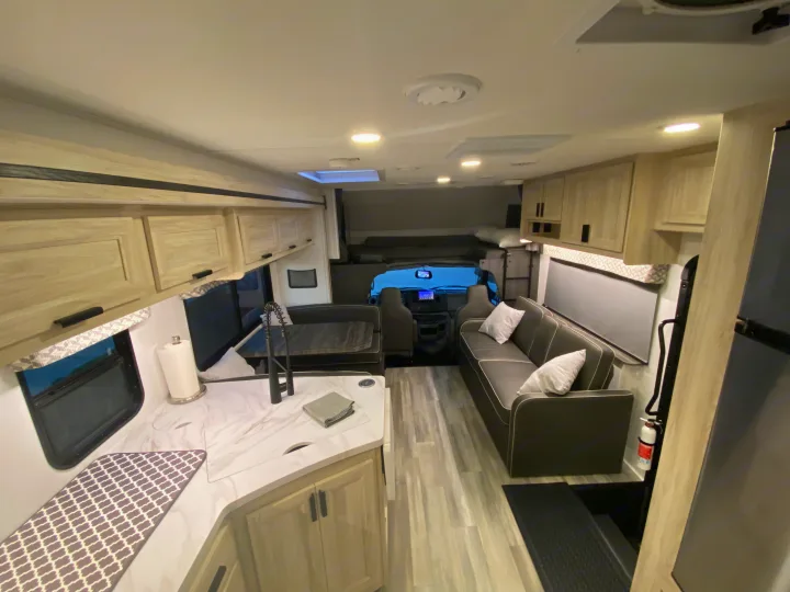 Spacious and modern RV rental interior with kitchen, living area, and cockpit, perfect for comfortable travels.. Forest River Forester 2023