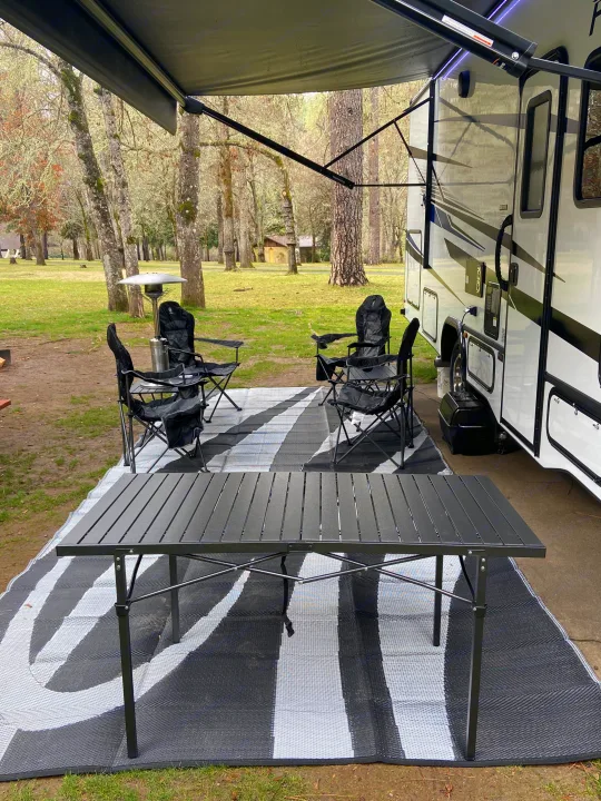 Relaxing RV rental campsite. Awning shades outdoor mat, chairs, and table. Perfect for nature lovers.. Forest River Forester 2023