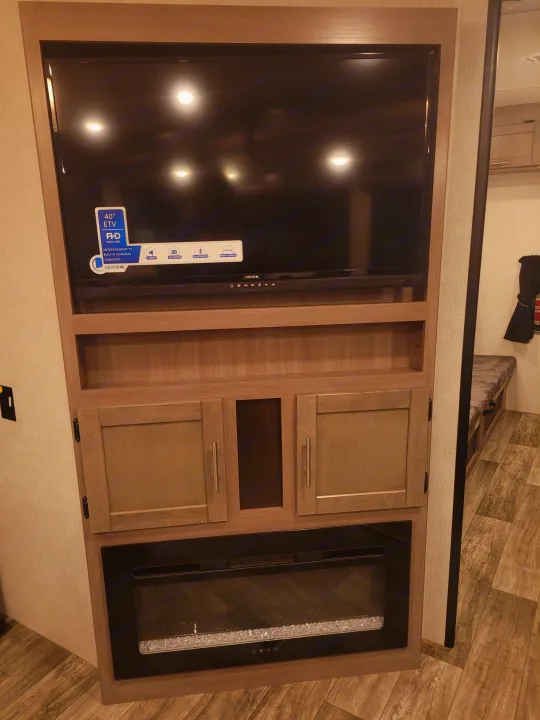 RV rental entertainment hub with 40" TV, soundbar, ample storage, and a cozy electric fireplace.. Crossroads Sunset Trail 2023