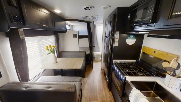 Step inside this RV rental's spacious interior: a dinette, full kitchen (stove, sink, fridge, microwave), and bunk beds.. Forest River Cherokee Grey Wolf Special Edition 2022