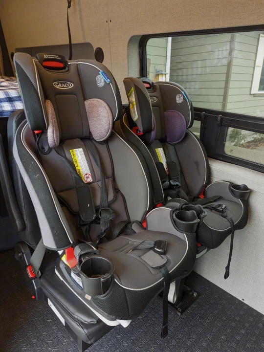 An RV rental's interior features two Graco child car seats, ensuring safe travels for families on the road.. Grit Overland GO A/T 2022