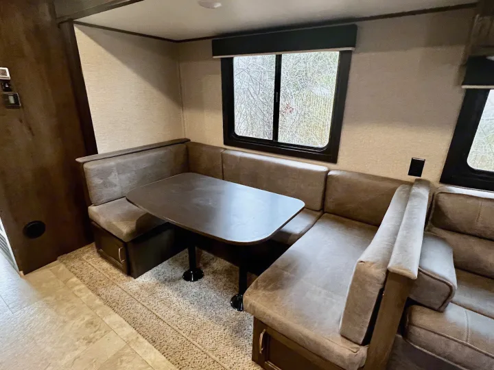 Modern RV rental interior: U-shaped dinette with comfortable seating and a sturdy table by the windows.. Jayco Jay Flight SLX 2020