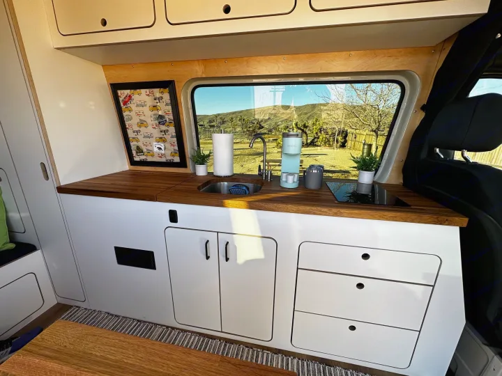 Spacious RV rental interior featuring a full kitchen, scenic window views, and ample storage for comfortable mobile living.. VanCraft VanCraft Class B 2022
