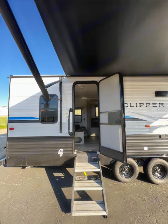 Modern Clipper travel trailer RV rental, with door open showing interior, extended awning, and entry steps, ready for your trip.. Coachmen Clipper 262 BH C 2023