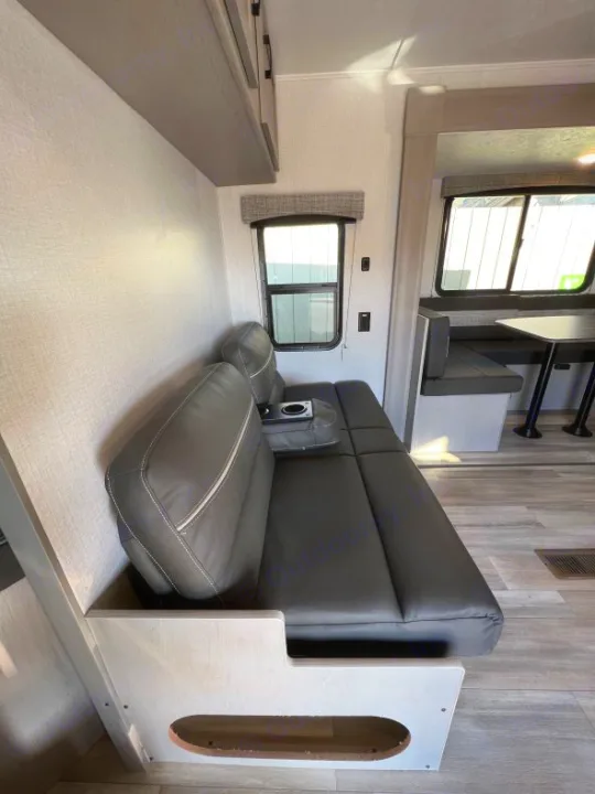 RV rental interior features a gray convertible sofa/bed, large windows, and overhead storage. Ideal for road trips.. Coachmen Clipper 262 BH C 2023
