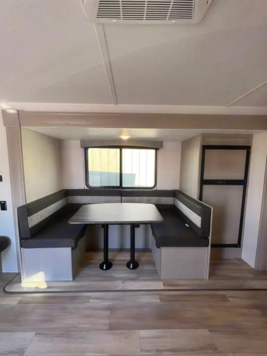 Experience your RV rental! Interior features a bright dinette with bench seating, table, and compact kitchen area. Note wood-look floor.. Coachmen Clipper 262 BH C 2023