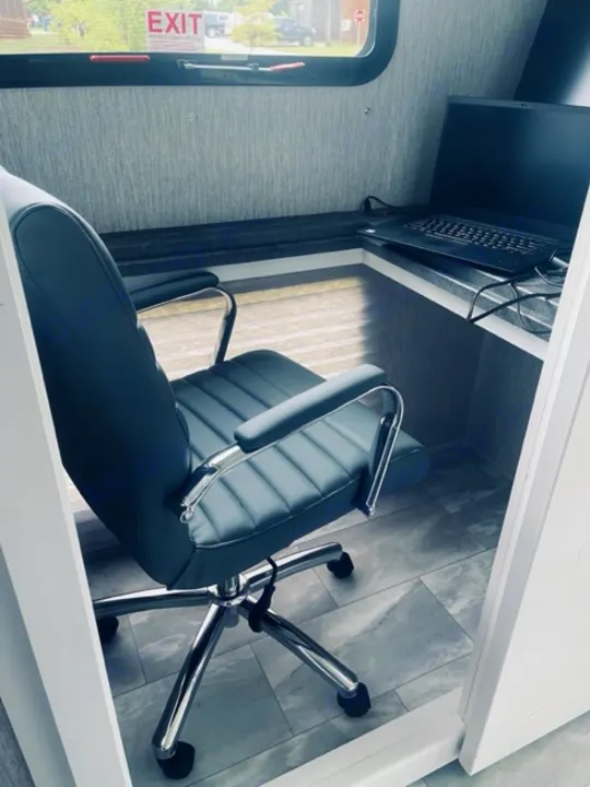 Dedicated office space in an RV rental, with a comfy chair, desk, and laptop. Ideal for a productive mobile workspace.. Other Other 2021