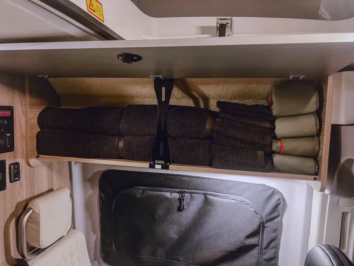 RV rental: Overhead cabinet organized with neatly rolled towels and camping supplies.. Winnebago Solis 59PX 2023