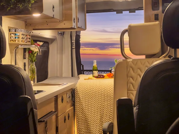 Panoramic ocean sunset from your cozy RV rental! Relax inside with a snack and wine by the built-in kitchen.. Winnebago Solis 59PX 2023
