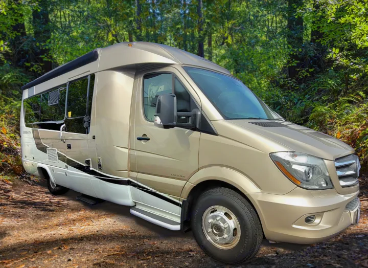 Gold Serenity camper van RV rental on a dirt forest path. Ready for your next adventure.. Leisure Travel Serenity 2016
